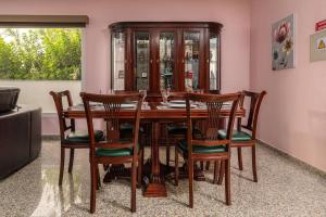滨海保尔Villa Salinas - Relax in the paradise surronded by nature and heated swimpool的一间带木桌和椅子的用餐室