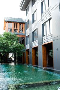 清迈Hotel Loy Chiang Mai的一座建筑前面有水池