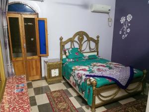 阿斯旺Labib Guest House的一间卧室配有一张带绿色棉被的床