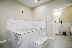 亨博尔温彻斯特套房饭店 - 汉布尔/乔治·布希洲际机场/北休斯顿的白色的浴室设有浴缸和卫生间。