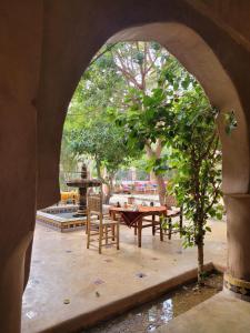 阿格兹Riad Tabhirte的通往带桌椅的庭院的拱门