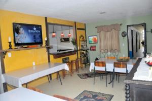 里约达欧特拉斯ANGEL'S SEA Pousada的厨房以及带桌子和电视的用餐室。