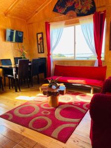 安库德Cabañas Agroturismo Pupelde的客厅配有红色沙发和红色地毯