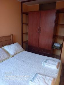 利马华琦公寓式酒店的一间卧室配有一张床和一个木制橱柜