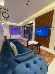 哈萨شاليه ريفو Revo chalet的客厅配有蓝色的沙发和电视