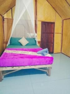 高兰安达曼湾简易别墅的一张位于带紫色床垫的房间内的床铺