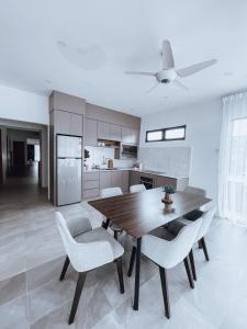 关丹Nur Villa Sg Soi的厨房配有木桌和白色椅子