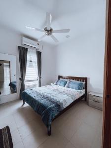 关丹Nur Villa Sg Soi的一间卧室配有一张带吊扇的床