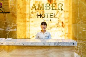 芽庄Amber Hotel managed by HT的站在旅馆柜台后面的女人