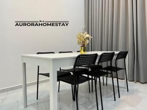 马兰Aurora Homes的客房内的一张带黑椅子的白色桌子
