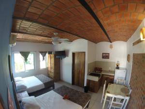 瓜亚比托斯Kiramar los Peyotes的一间卧室配有一张床铺和一张桌子,还设有一间厨房
