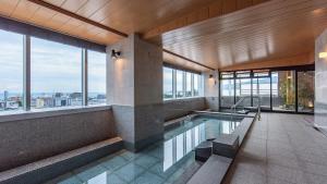 小田原市Tenseien Odawara Station Annex的一座带窗户的建筑中的游泳池