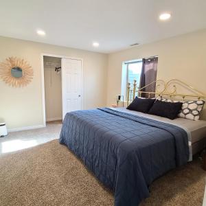盐湖城Entire Cozy Basement! Private Entrance! - Fast Wifi!的一间卧室配有一张带蓝色毯子的大床