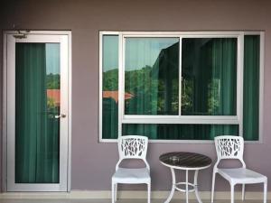 珍南海滩王谷度假酒店的窗前的两把椅子和一张桌子