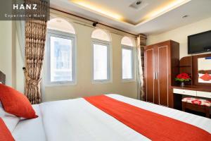 胡志明市HANZ Beautiful Boutique Hotel Saigon的一间卧室配有一张床、电视和窗户