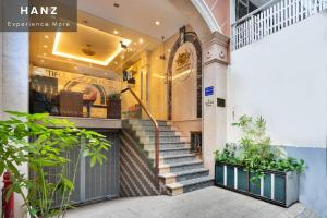 胡志明市HANZ Beautiful Boutique Hotel Saigon的商店前有楼梯的建筑