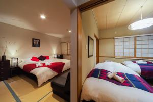 白马村Luna Lodge的一间卧室配有两张红色和白色的床