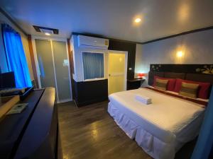 攀牙帕科尔精品度假酒店的一间卧室配有一张床和一张书桌及电视