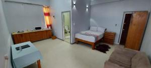 霍尼亚拉Marine Apartments的一间卧室配有一张床、一把椅子和镜子