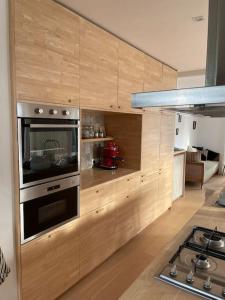 科克赛德Zeehuis的厨房配有木制橱柜和炉灶烤箱。
