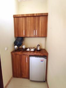 吉利特拉旺安萨哈巴别墅的一间带木制橱柜和冰箱的小厨房