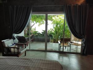 科隆万Sea Sand House Resort的一间卧室设有一张床和一个大型滑动玻璃门