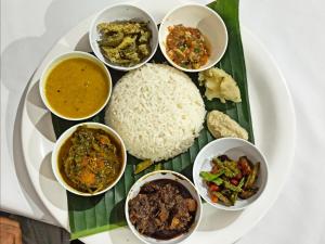 焦尔哈德Assam Villa - by Storyweavers Retreat的饭和不同种类食物的盘子