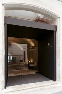 莫拉-迪巴里Le Carasse Boutique Hotel的通往带大玻璃窗的大楼的门道