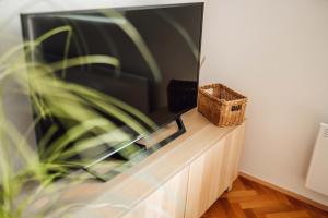 卢布尔雅那White Apartment的木制橱柜顶部的平面电视