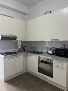 布鲁塞尔L Escapade Urbaine的厨房配有白色橱柜和炉灶烤箱。