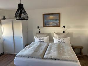 沃尔加斯特Hafenkoje Zum Anker的一间卧室配有带白色床单和枕头的床。