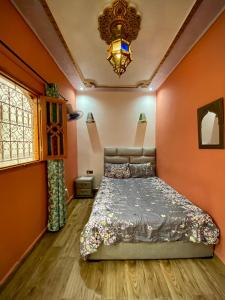拉巴特Riad Najiba的一间卧室配有一张带橙色墙壁和吊灯的床。