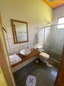 瓦尔任博尼塔Pousada Vale dos Diamantes的一间带水槽、卫生间和镜子的浴室