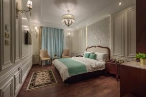 亚历山大Miramar Boutique Hotel的一间卧室配有一张床和一个吊灯