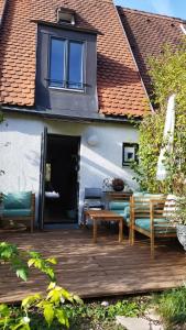 慕尼黑Atelier & Gardenhouse Glamping的一个带长椅和桌子的木制甲板和一座建筑