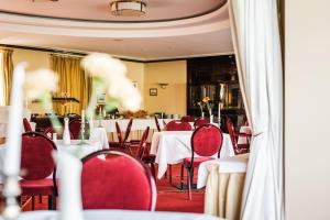 温克尔瑞恩斯尔兹酒店的一间设有白色桌子和红色椅子的餐厅