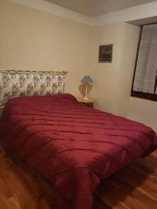 库马约尔Villa Tancredi的一间卧室配有一张带红色毯子的床