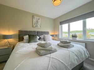 肯德尔'Benson View' - 2 bedroom Lake District home的卧室配有带毛巾的大型白色床