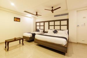 钦奈Hotel Comfort Park - Opposite Sri Ramachandra Medical College Porur的一间卧室配有两张床和一张桌子