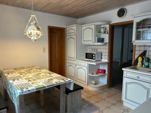 罗登巴赫Maisonettewohnung mit Terrasse und Homeoffice的厨房配有白色橱柜和桌子