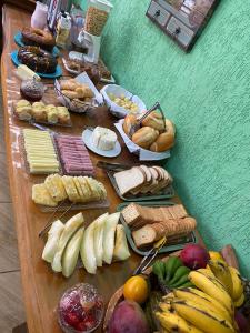 圣本图-杜萨普卡伊Chalés Sapucaí Pousada的填满不同种类面包和水果的桌子