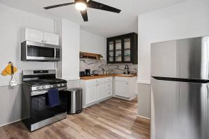克利夫兰Center of Little Italy #4的厨房配有白色橱柜和黑色冰箱。