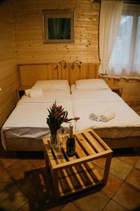 Osiek迪瓦尔酒店的一间卧室设有两张床和一张桌子,并提供一瓶葡萄酒