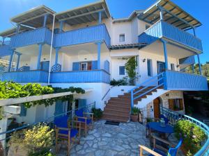 阿约斯尼奇塔斯Pantazis Studios in Agios Nikitas的蓝色阳台和桌椅的房子