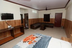 伯杰默里Jain Residency的一间卧室配有一张床和一台平面电视