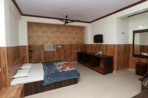 伯杰默里Jain Residency的一间卧室配有一张床和一台电视