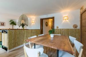 马德里Santo - Coworking - Coliving - Madrid的一间带木桌和白色椅子的用餐室