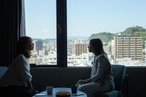 鹿儿岛FAV HOTEL KAGOSHIMACHUO的两个女人坐在窗外的房间