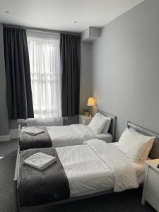 伦敦拉夫纳格拉酒店的酒店客房设有两张床和窗户。