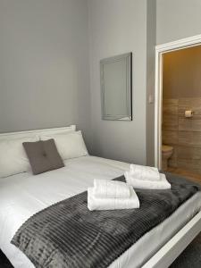 伦敦拉夫纳格拉酒店的一张白色的床,上面有两条毛巾